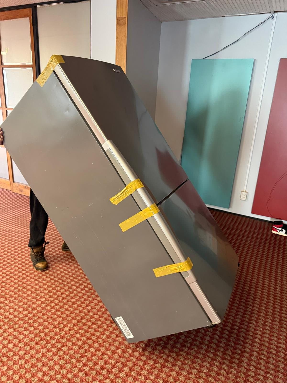 Fridge doors taped shut and carried upright with care